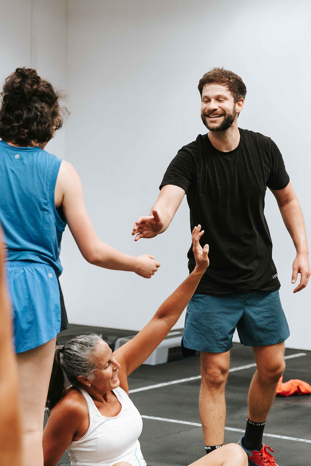 Coach high-fiving a member on the gym floor at Hustle & Thrive Heidelberg