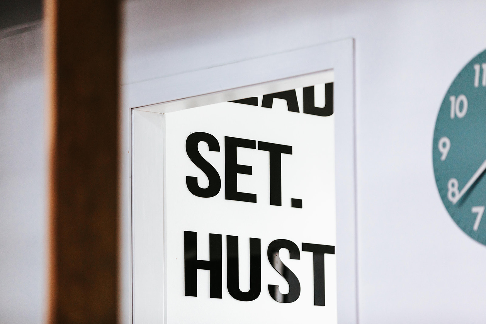 Ready. Set. Hustle. signage beside the studio clock