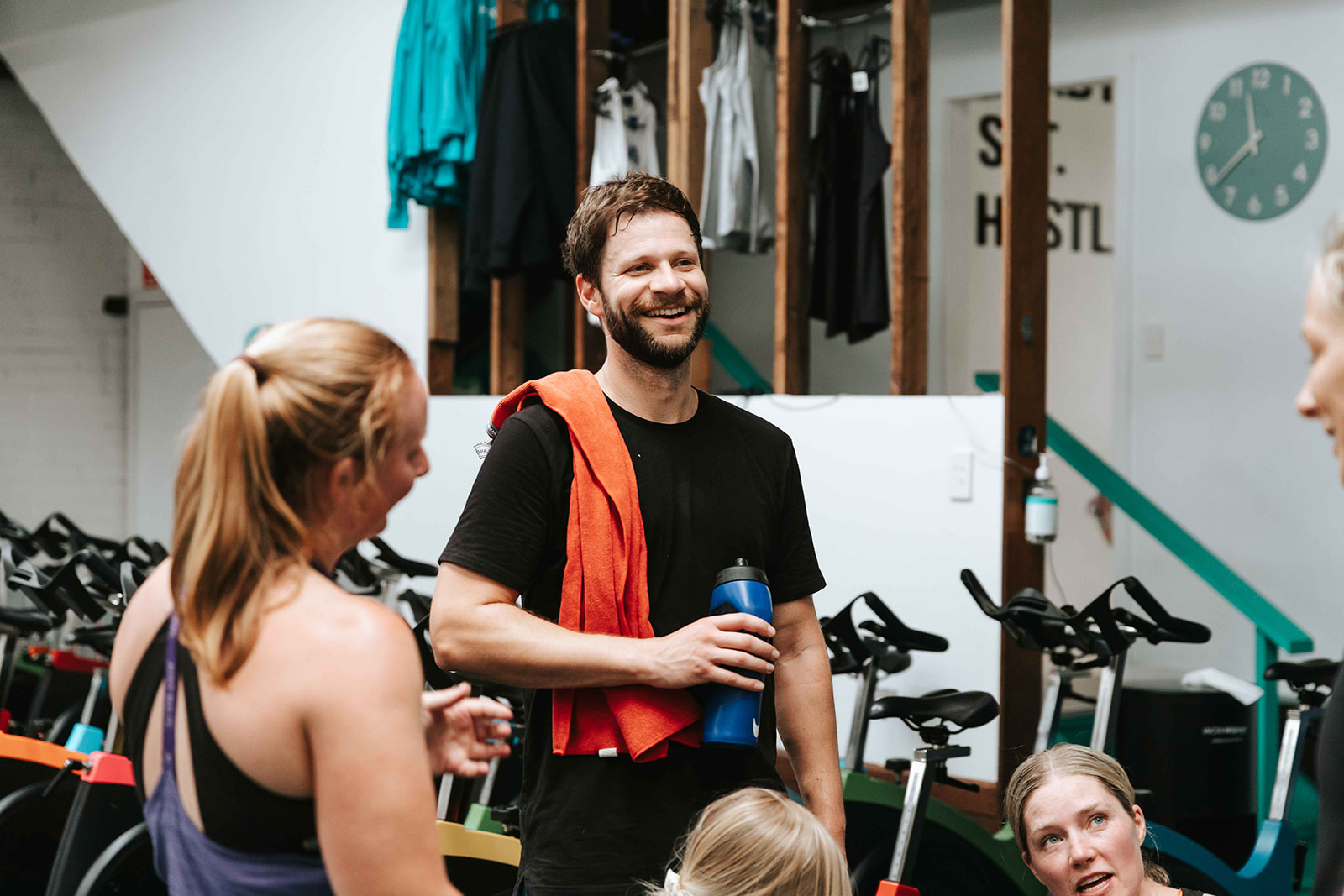 Coach chatting with members before a spin session